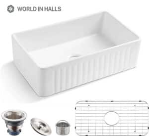 Rectangular white ceramic farmhouse kitchen sink with fluted front design and included drain accessories.