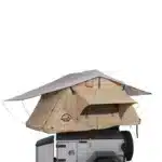 A beige and grey roof top tent with an extended awning, featuring a large window
